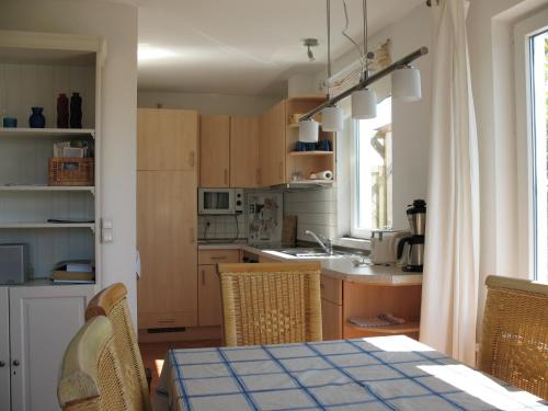 a kitchen with wooden cabinets and a table with chairs at Ferienhaus Seeblick 39 in Holnishof