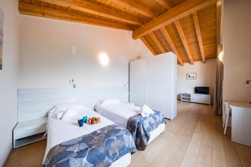 two beds in a room with wooden ceilings at Comacina Villa in Como
