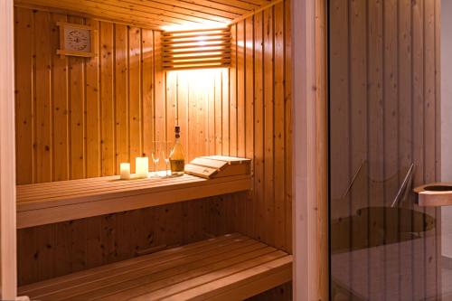 sauna in legno con bottiglia di vino e candele di Comacina Villa a Como