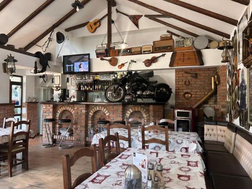 a restaurant with tables and a motorcycle on the wall at Pensiunea TOTAL din Ceahlău in Ceahlău