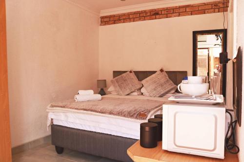 a bedroom with a bed with a tv in it at Renosterberg by KLG in Kimberley
