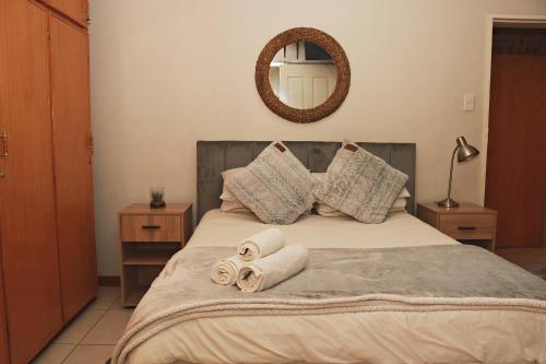 a bedroom with a bed with two rolled towels at Renosterberg by KLG in Kimberley