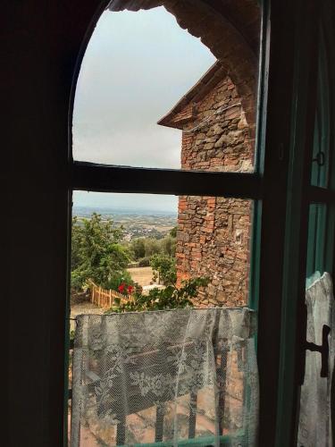 a window with a view of a brick chimney at Poderino La Noce in Vinci