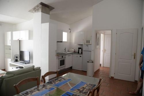 a living room with a table and a kitchen at Bel Appartement En Haut de Villa in Sanary-sur-Mer