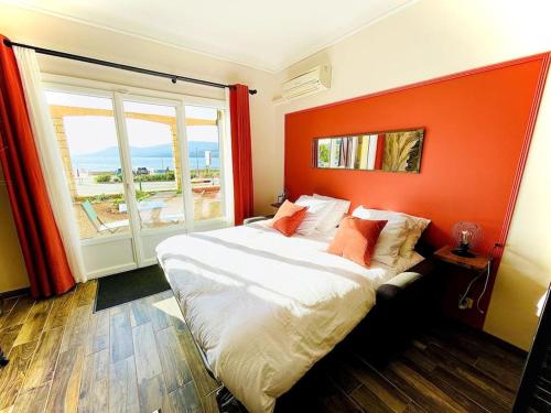 um quarto com uma cama grande e uma parede laranja em Appartement Propriano Corse du Sud Face à la Mer em Propriano