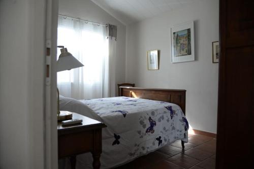 a bedroom with a bed and a table and a window at Bel Appartement En Haut de Villa in Sanary-sur-Mer