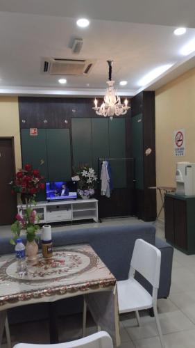 a living room with a table and a tv at Doris Hotel in Malacca