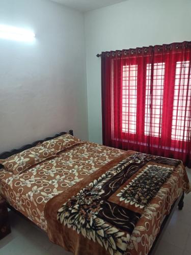 a bed in a bedroom with red windows at Beach Villa Kovalam in Kovalam