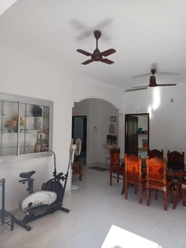 a living room with a ceiling fan and a table and chairs at Beach Villa Kovalam in Kovalam