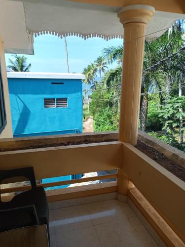 a room with a window with a view of palm trees at Beach Villa Kovalam in Kovalam