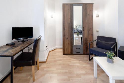 a living room with a desk with a television and a chair at Vogelsberger Bett 5 die 1 links in Alsfeld