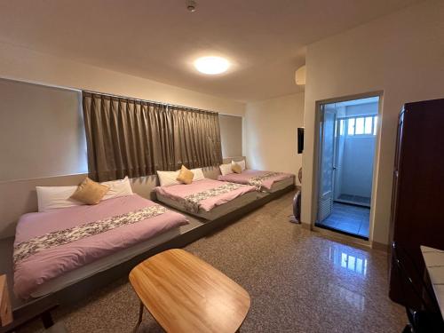 a room with two beds and a table and a window at Royal Yado in Zhixue