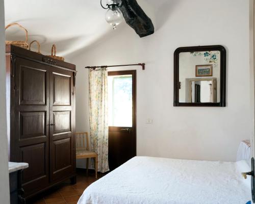 - une chambre avec un lit et un miroir mural dans l'établissement Casa del Pastore, à Stellanello