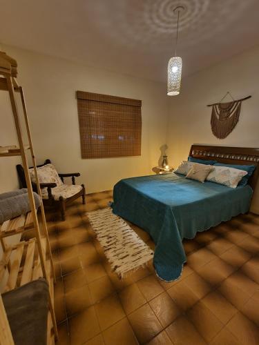 1 dormitorio con 1 cama, 1 silla y 1 escalera en Daldeia, en São Pedro da Aldeia