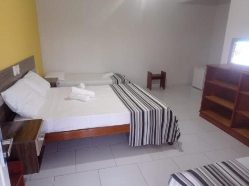 una camera da letto con un letto e un asciugamano sopra di Hotel Mata Atlântica a Corumbau