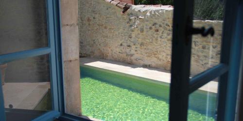 uma janela com vista para uma piscina de água em La Planque des Frères em Rivières