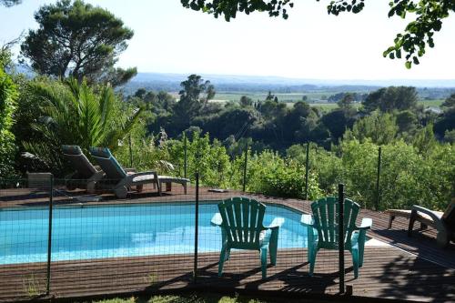 two chairs sitting next to a swimming pool at Chalet, calme, absolu, superbe vue, et piscine (en été) in Ventenac-Cabardès