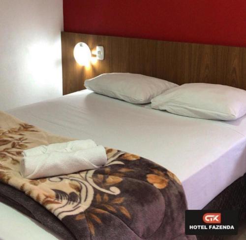 uma cama com duas almofadas e um cobertor em hotel fazenda ctk em Santa Cruz do Sul