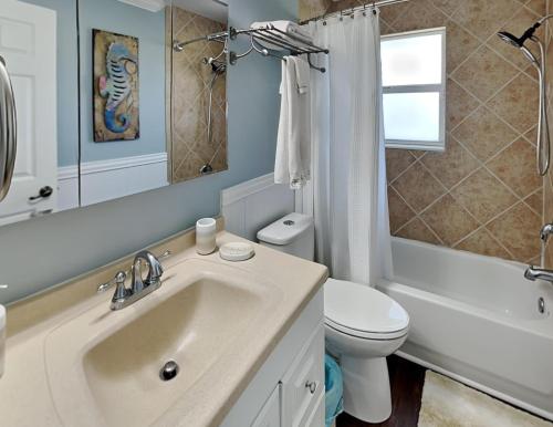 een witte badkamer met een wastafel en een toilet bij The Sea Star in Fort Myers