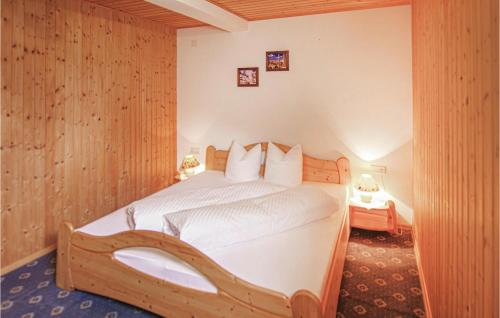 um quarto com uma cama e uma parede de madeira em Awesome Apartment In St, Gallenkirch With Ethernet Internet em Sankt Gallenkirch