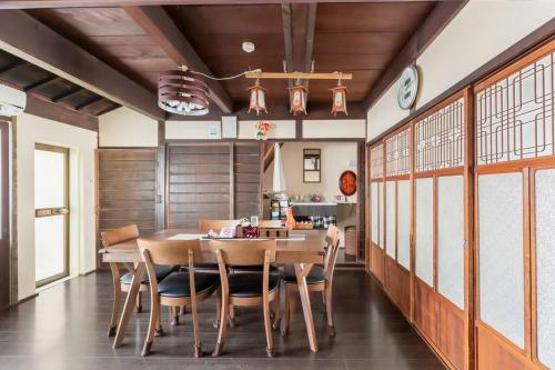 uma sala de jantar com uma mesa de madeira e cadeiras em KIX House Wakeikan 和憩館 em Izumi-Sano