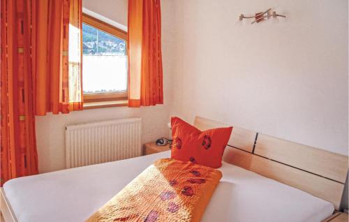 a bedroom with a bed with orange curtains and a window at Nice Apartment In Pfunds With 2 Bedrooms And Wifi in Pfunds