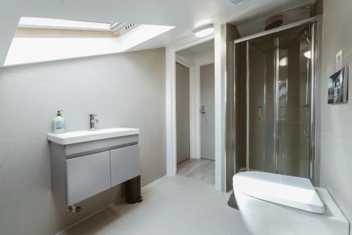 a white bathroom with a sink and a shower at Fulham Guest Studios 268 in London