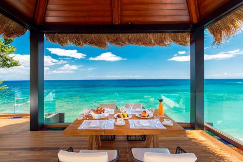 a dining table with a view of the ocean at Porto Zante Villas And Spa in Tragaki