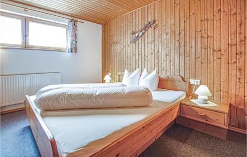 ザンクト・ガレンキルヒにあるLovely Apartment In St, Gallenkirch With Kitchenの木製の壁にベッド2台が備わるベッドルーム1室