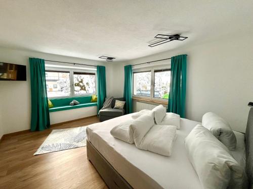 1 dormitorio con 1 cama blanca grande y cortinas verdes en Apart Aurelia en Längenfeld