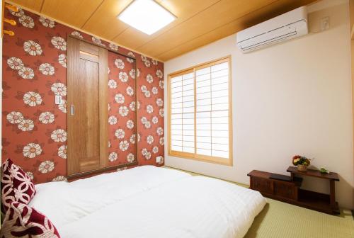 a bedroom with a bed and a window at KYO SAKURA Shimabara 2F in Kyoto