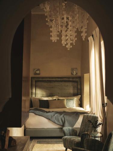 a bedroom with a bed and a chandelier at IZZA Marrakech in Marrakech