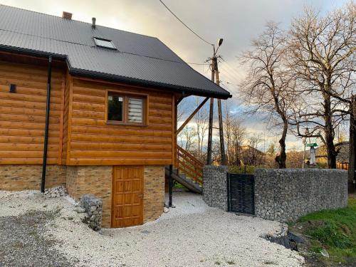 a log cabin with a black roof and a door at Dom w górach z bilardem in Juszczyna