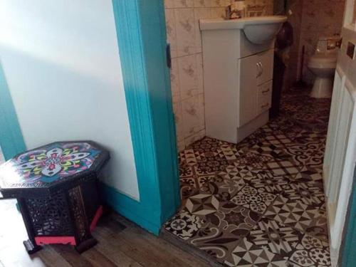 baño con aseo y lavamanos y suelo en Hostel Don Poncho, en Valparaíso