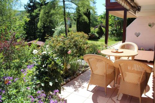 eine Terrasse mit einem Tisch, Stühlen und Blumen in der Unterkunft Wohlfühlgästehaus Eva-Maria Schätzle in Schonach