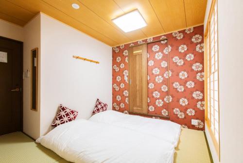 a bedroom with a bed and a wall with flowers at KYO SAKURA Shimabara 2F in Kyoto