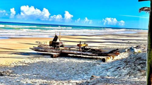 łódź siedząca na plaży w pobliżu oceanu w obiekcie Chalé Sargi Serra Grande w mieście Serra Grande