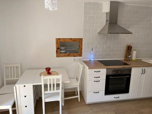 a kitchen with white cabinets and a table and a stove at Apto. Rural Cielo. Al lado Torre in Jérica