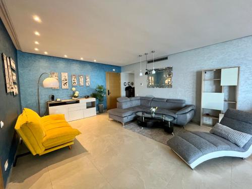 een woonkamer met een bank en een gele stoel bij Sunset Lover Sea View Luxury Apartment in Tanger