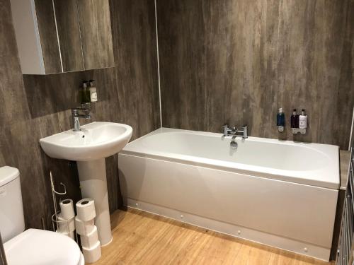 a bathroom with a white tub and a sink at Nellies Shed, Wolds Way Holiday Cottages, 3 bed spacious cottage in Cottingham
