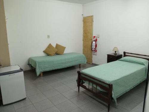 a room with two beds and a refrigerator at B&B Luján de Cuyo in Ciudad Lujan de Cuyo