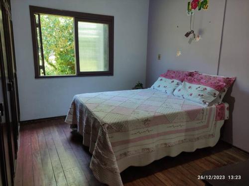 een slaapkamer met een bed en een raam bij Casa de campo, Piscina e Cristo in Encantado