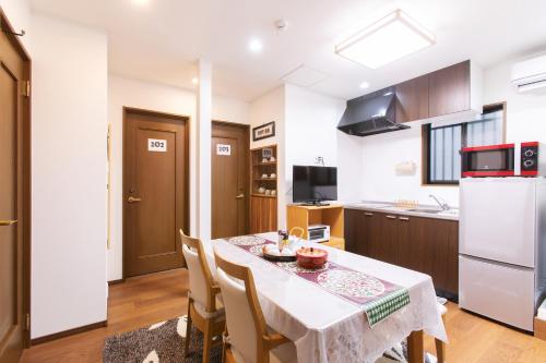a kitchen and dining room with a table and chairs at KYO SAKURA Shimabara 2F in Kyoto