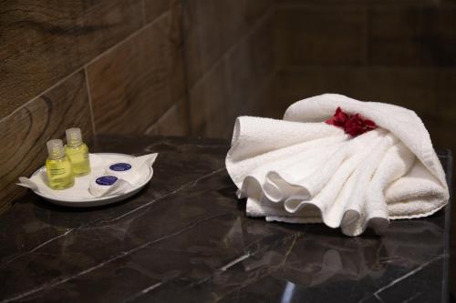 een handdoek op een tafel met een bord handdoeken bij RS Hotel Karam Palace in Ouarzazate
