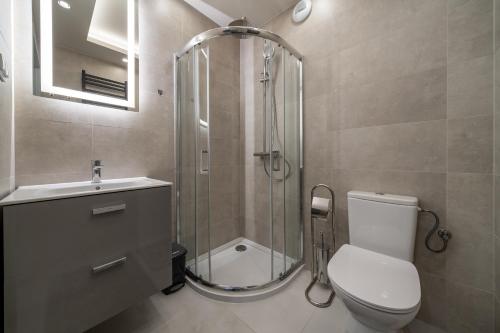 a bathroom with a shower and a toilet and a sink at RentPlanet - Apartamenty Zakopiańskie in Zakopane