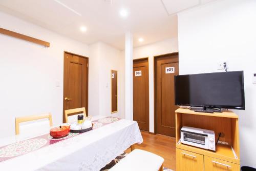 a living room with a flat screen tv on a table at KYO SAKURA Shimabara 2F in Kyoto