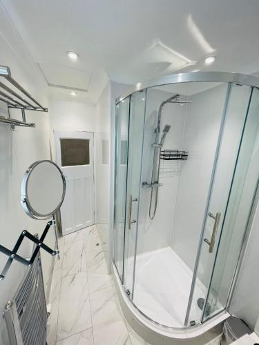 a bathroom with a shower with a glass shower stall at Ravensbury Home in Mitcham