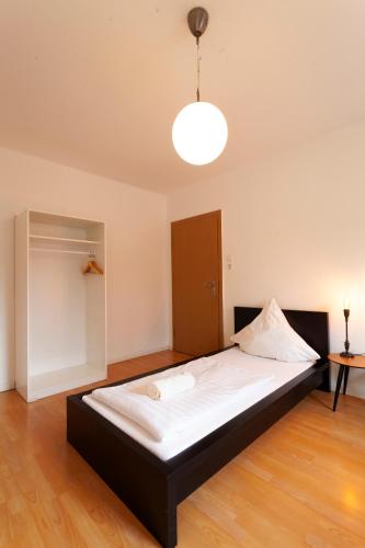 a large bed in a room with a light at City Apart Hannover in Hannover