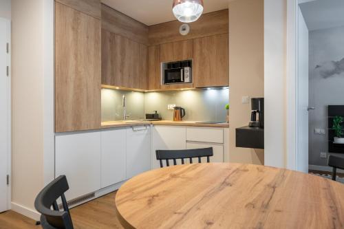 a kitchen and dining room with a wooden table at RentPlanet - Apartamenty Zakopiańskie in Zakopane