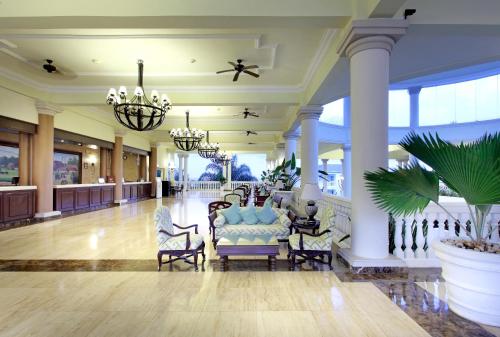 a lobby with chairs and chandeliers in a building at Grand Palladium Jamaica Resort & Spa All Inclusive in Lucea